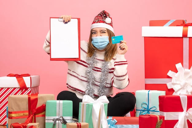 Vue de face jeune femme assise autour de cadeaux