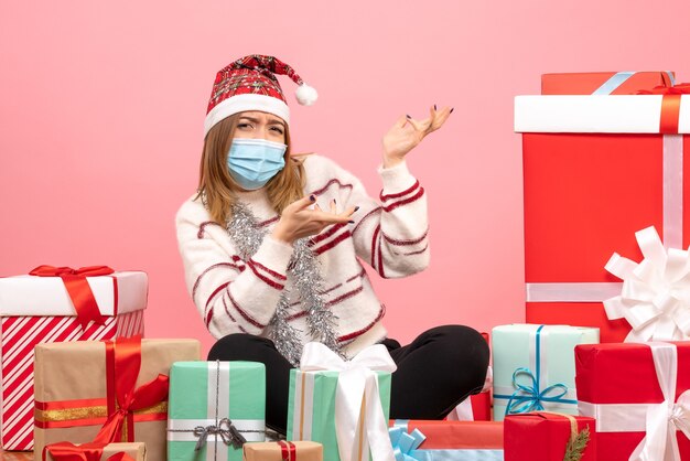 Vue de face jeune femme assise autour de cadeaux