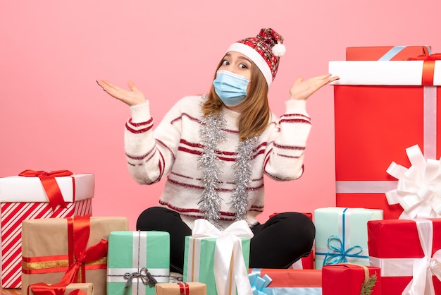 Vue de face jeune femme assise autour de cadeaux