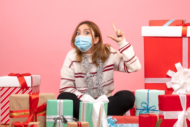 Vue de face jeune femme assise autour de cadeaux