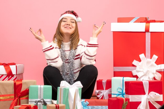 Vue de face jeune femme assise autour de cadeaux