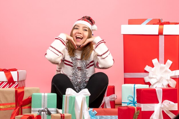 Vue de face jeune femme assise autour de cadeaux