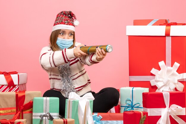 Vue de face jeune femme assise autour de cadeaux