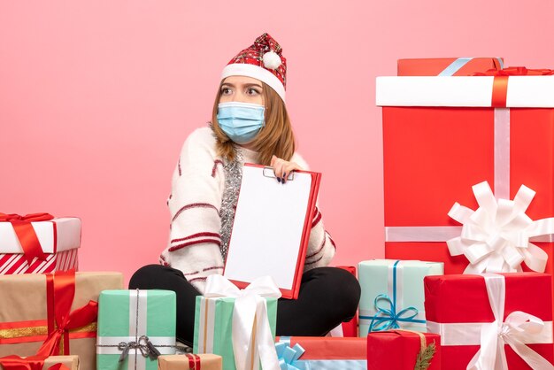 Vue de face jeune femme assise autour de cadeaux