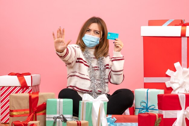 Vue de face jeune femme assise autour de cadeaux