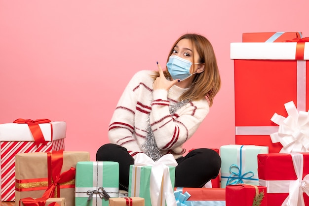 Vue de face jeune femme assise autour de cadeaux