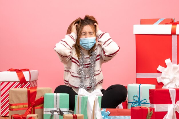 Vue de face jeune femme assise autour de cadeaux