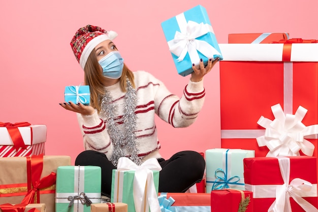 Vue de face jeune femme assise autour de cadeaux