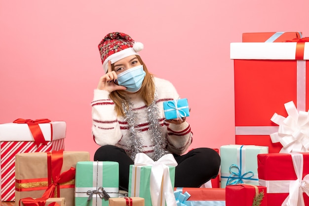 Vue de face jeune femme assise autour de cadeaux