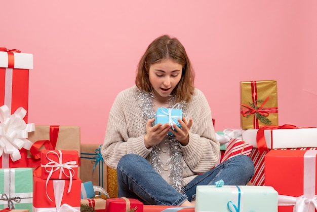 Vue de face jeune femme assise autour de différents cadeaux