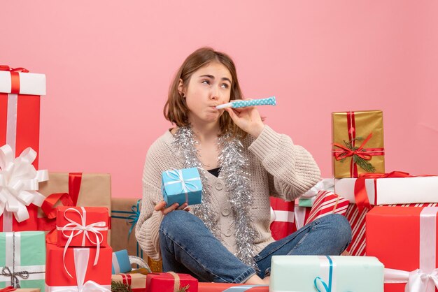 Vue de face jeune femme assise autour de différents cadeaux