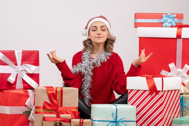 Vue de face jeune femme assise autour de Noël présente méditer