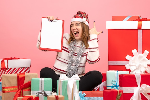 Vue de face jeune femme assise autour de Noël présente avec note de fichier