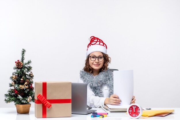 Vue de face jeune femme au lieu de travail travaillant avec des documents sur fond blanc