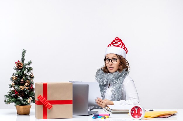 Vue de face jeune femme au lieu de travail travaillant avec des documents sur fond blanc