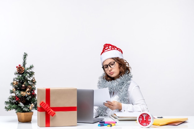 Vue de face jeune femme au lieu de travail travaillant avec des documents sur fond blanc