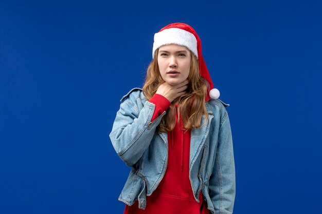 Vue de face jeune femme ayant des problèmes de gorge sur fond bleu couleur de l'émotion de Noël