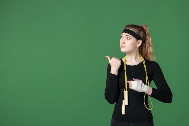 Vue de face jeune femme avec un bandage autour de son bras blessé sur fond vert athlète douleur santé blessure hôpital sport corps d'entraînement