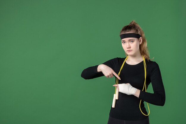 Vue de face jeune femme avec un bandage autour de son bras blessé sur fond vert athlète entraînement flex santé femme blessure sport corps hôpital