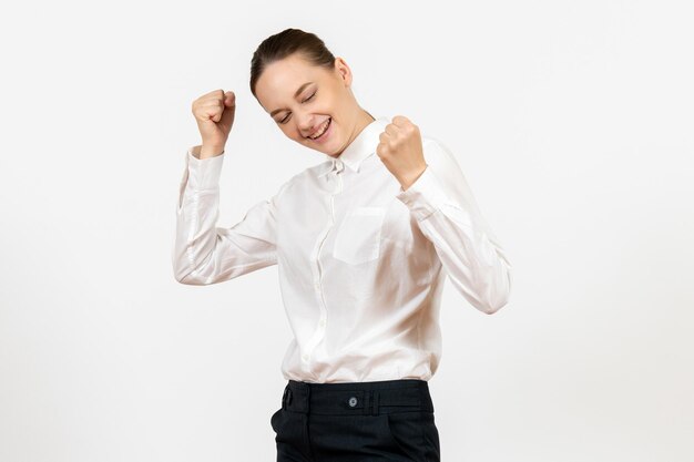 Vue de face jeune femme en blouse blanche avec une expression ravie sur fond blanc modèle de sentiment d'émotion de bureau d'emploi féminin