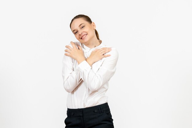 Vue de face jeune femme en blouse blanche avec une expression ravie sur fond blanc sentiment féminin modèle bureau émotion travail