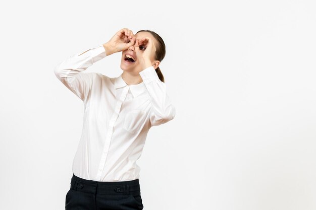 Vue de face jeune femme en blouse blanche avec visage excité sur fond blanc bureau d'emploi femme sentiment modèle émotion