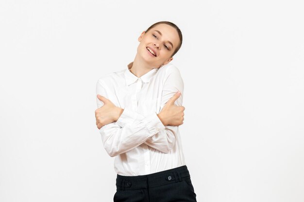 Vue de face jeune femme en blouse blanche avec un visage ravi sur fond blanc travail de bureau émotions féminines modèle de sentiment