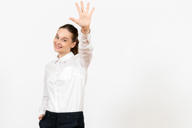 Vue de face jeune femme en blouse blanche avec visage souriant sur fond blanc bureau d'emploi femme sentiment modèle émotions