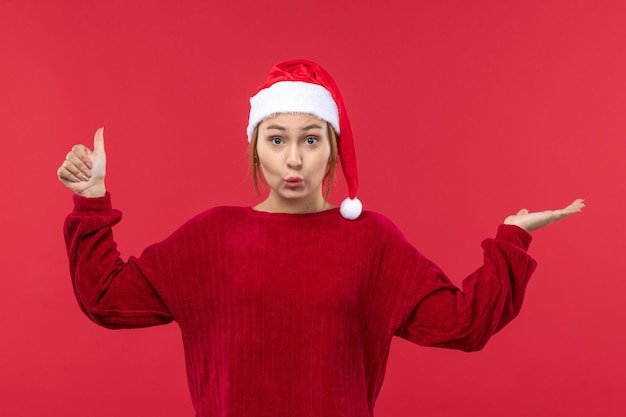 Vue de face jeune femme en bonnet rouge humeur de Noël, Noël de vacances rouge