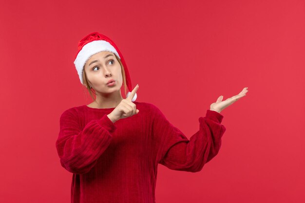 Vue de face jeune femme en bonnet rouge humeur de Noël, Noël de vacances rouge