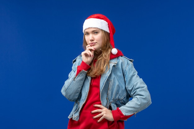 Vue de face jeune femme avec bonnet rouge pensant sur l'espace bleu