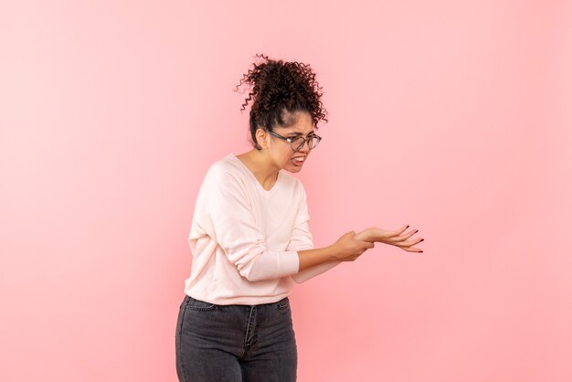 Vue de face de la jeune femme avec bras blessé sur le mur rose