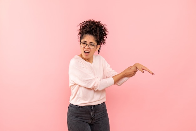 Vue de face de la jeune femme avec bras blessé sur le mur rose