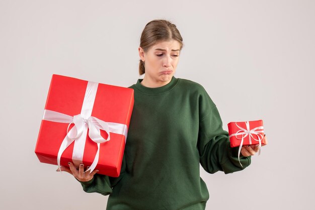 Vue de face jeune femme avec des cadeaux de Noël