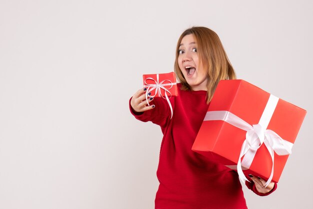 Vue de face jeune femme avec des cadeaux de Noël