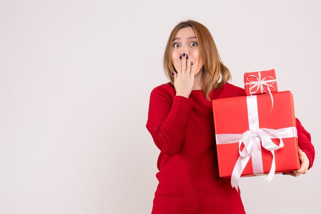 Vue de face jeune femme avec des cadeaux de Noël