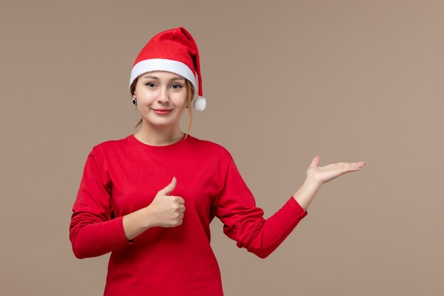 Vue de face de la jeune femme avec cape de Noël sur brown