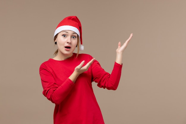 Vue de face de la jeune femme avec cape de Noël sur brown