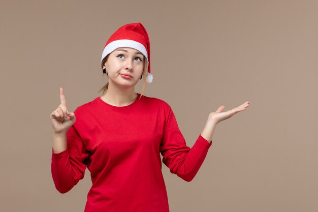 Vue de face de la jeune femme avec cape de Noël sur brown