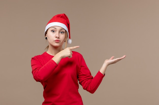 Vue de face de la jeune femme avec cape de Noël sur brown