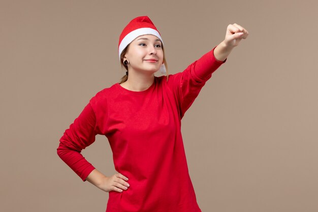 Vue de face de la jeune femme avec cape de Noël sur brown