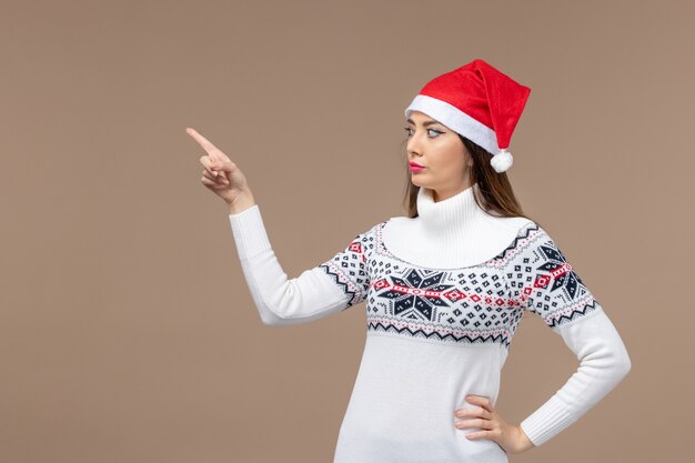 Vue de face jeune femme avec cape rouge sur fond marron nouvel an émotion noël