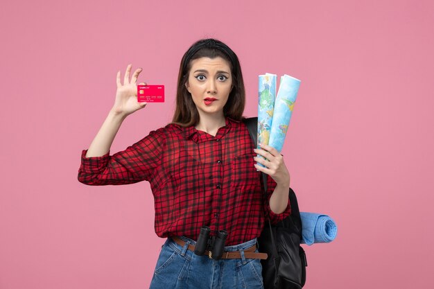 Photo gratuite vue de face jeune femme avec des cartes et carte bancaire sur le bureau rose couleur femme humaine
