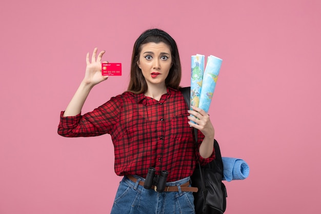 Vue de face jeune femme avec des cartes et carte bancaire sur le bureau rose couleur femme humaine