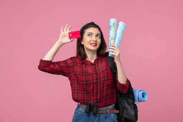 Vue de face jeune femme avec cartes et carte bancaire sur le bureau rose femme couleur humaine