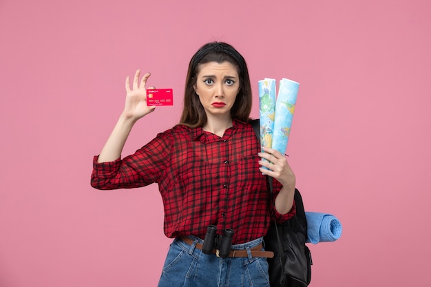 Vue de face jeune femme avec cartes et carte bancaire sur fond rose clair couleur femme humaine