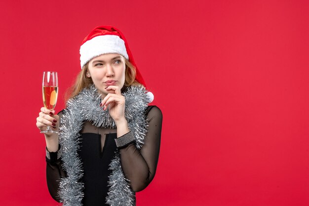 Vue de face jeune femme célébrant le nouvel an sur un mur rouge vacances émotion noël