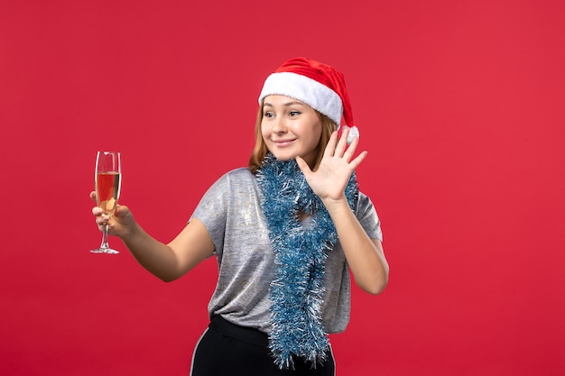 Vue de face jeune femme célébrant le nouvel an sur le sol rouge vacances de Noël couleur