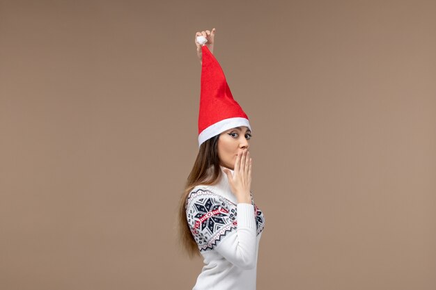 Vue de face jeune femme avec chapeau de Noël sur le fond marron vacances Noël émotion