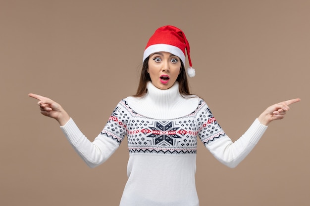 Photo gratuite vue de face jeune femme avec chapeau de noël rouge sur le bureau marron noël nouvel an émotion